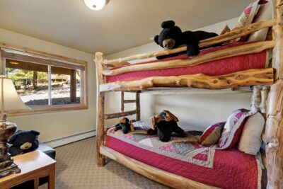 Rustic bunk beds with stuffed animals in an cozy room.